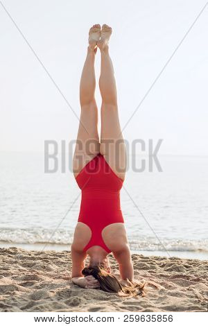 Young Woman Doing Complex Yoga Exercise Headstand. Attractive Woman Practicing Yoga Concept, Standin