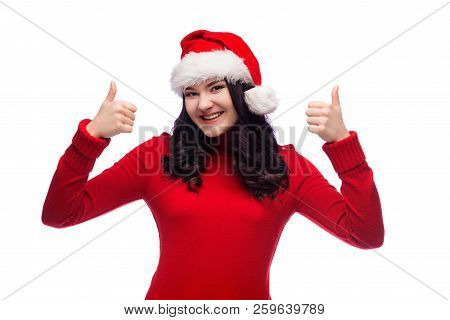 Portrait Of Brunette Cheerful Woman Wearing Santa Hat Smiling And Raising Her Thumb Up, Concept Of S