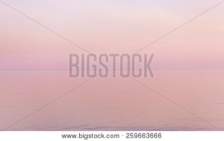 Beautiful Sunset In Pastel Tones Reflect Calm Water Surface.
