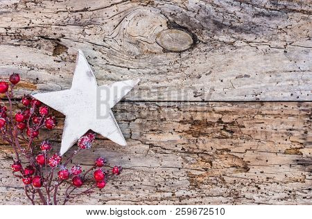 Christmas Decoration With White Star Shape And Red Berries On Old Wood Background With Copy Space