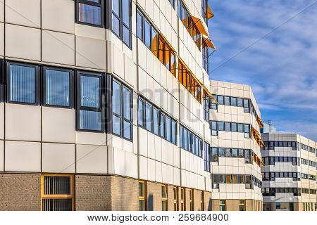 Classical White And Black Hospital Buildings On A Row Under Blue Sky With High Clouds