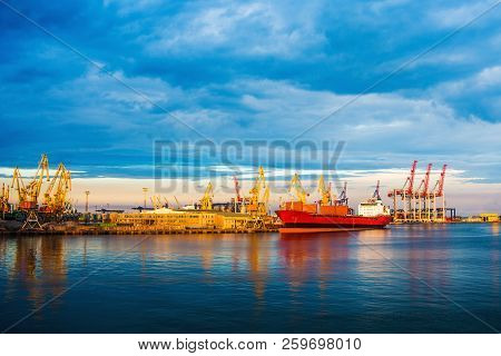 Bulker Enters The Seaport For Loading. Sunset. Calm Sea. Business For The Transport Of Goods. Ship. 