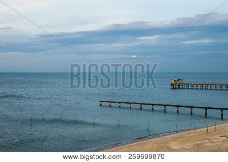 Beach, Bridge And The Moon Is Rising At 
Nim Seng Beach, Songkhla, Thailand.