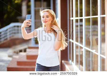 Attractive Smiling Woman Using Smartphone Outdoors. Lefestyle Concept