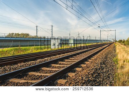 Rail Tracks On Sleepers And Basalt Gravel In The Netherlands. The Photo Was Taken On A Sunny Summer 