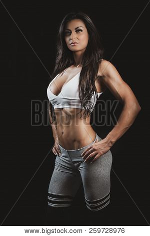 Beautiful Sporty Fit Woman In Studio On A Black Background, Perfect Abdominals Abs. Young Gym Woman 