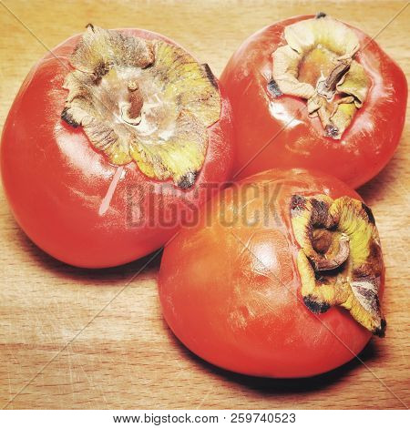Close Up Of Ripe Sweet Persimons On Rustic Wooden Table