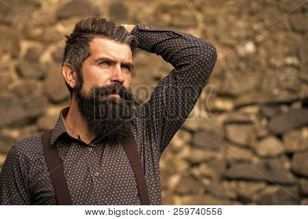 Closeup View Of One Handsome Senior Man With Black Hair And Long Lush Beard In Blue Shirt And Purple