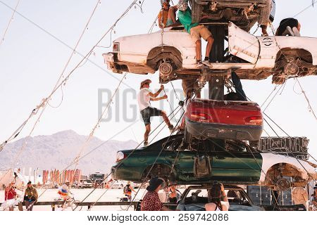 Guatemala - July 30, 2018. People Climbing Up The Huge Art Car Installation In The Middle Of A Deser
