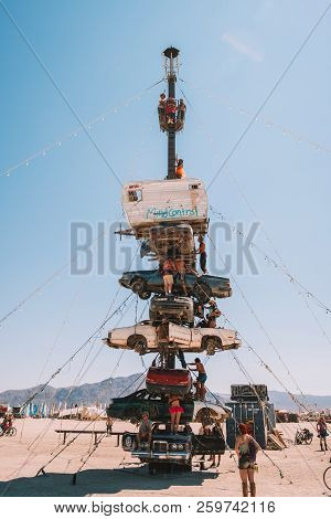 Guatemala - July 30, 2018. People Climbing Up The Huge Art Car Installation In The Middle Of A Deser