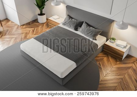 Top View Of White Wall Minimalistic Bedroom With A Wooden Floor, A Grey Carpet With Masterbed Standi
