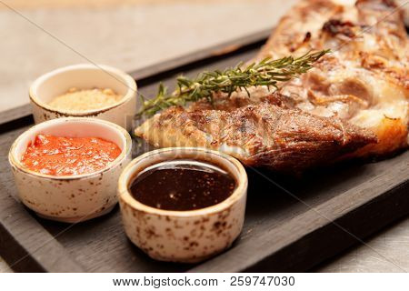 Grilled lamb meat with sauces, close-up