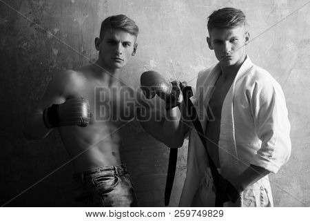Athletic Men Twins Posing On Beige Wall. Young Boxer With Naked, Fit, Muscular Torso In Red Boxing G