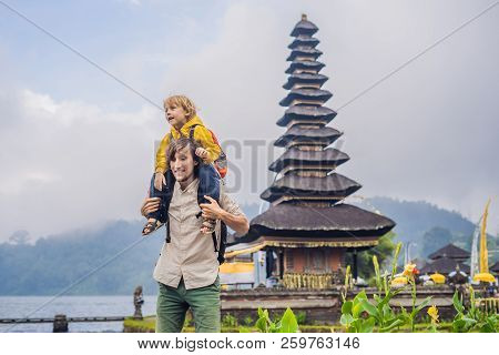 Dad And Son In The Background Of Pura Ulun Danu Bratan, Bali. Hindu Temple Surrounded By Flowers On 