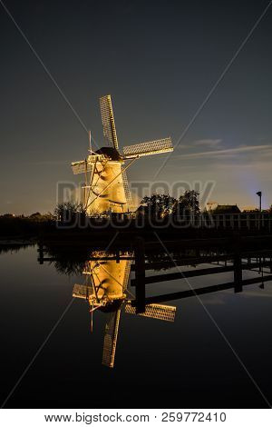 These Beautiful Windmills In Kinderdijk Are Illuminated With White Light At The Blue Hour