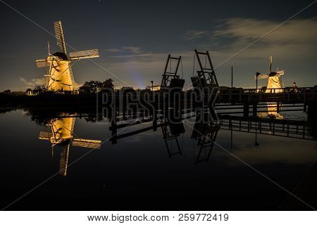 These Beautiful Windmills In Kinderdijk Are Illuminated With White Light At The Blue Hour