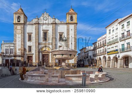 Evora, Portugal - December 1, 2017: Santo Antao Church and the 15th century Fonte Henriquina Fountain in the Giraldo Square. Renaissance architecture. 