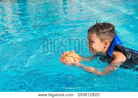 Happy Kid In Vest At Swimming Pool With Ball. Chilhood, Leisure, Swimming Theme