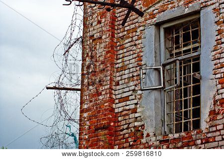 A Window In A Russian Prison Cell With Bars And Barbed Wire In An Old Prison - A Fragment Of An Unre