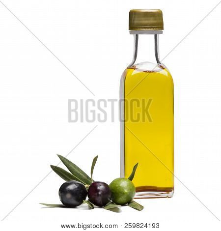 Glass Bottle Of  Cold-pressed Premium Virgin Olive Oil And Some Colorful And Organic Olives With Lea