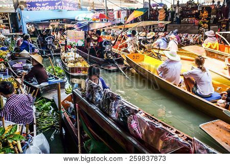 BANGKOK – MARCH 18: People shopping food from wooden boats at Amphawa floating market on March 18, 2