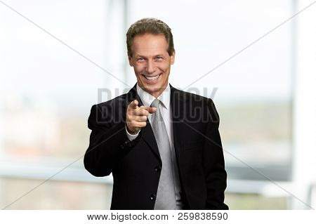 Happy Businessman Pointing With Finger Forward. Joyful Mature Man In Business Suit Indicating With F
