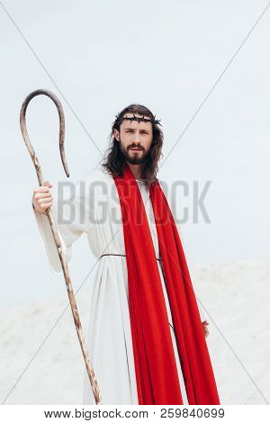 Jesus With Long Hair Standing With Wooden Staff In Desert