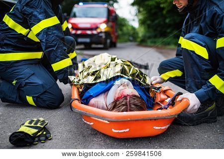 An Injured Woman In A Plastic Stretcher After A Car Accident, Covered By Thermal Blanket.