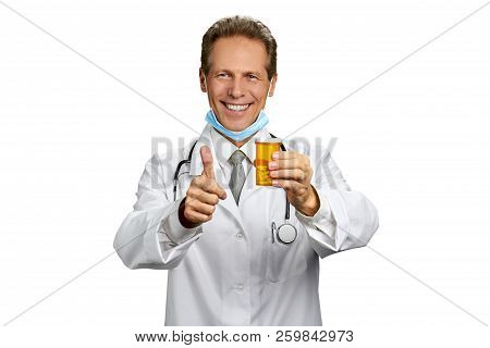Happy Doctor With Thumb Up Gesture. Portrait Of Cheerful Doctor Man Hoding Bottle With Pills And Ges