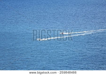 Two Water Motorcycles Ride Through The Blue Sea At A Speed.