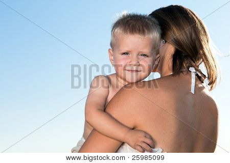 La muchacha abrazando a la madre contra el cielo