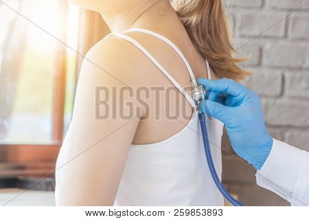 Young Woman At Clinic And Doctor Health Check Using Stethoscope, Heathcare And Medicineconcept