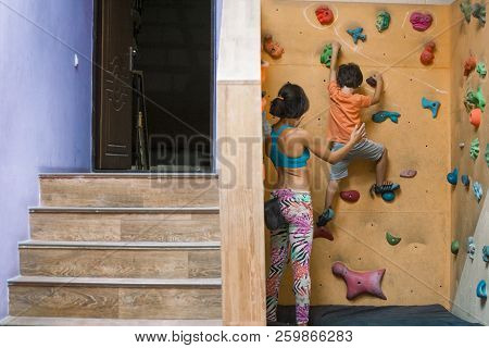 The Boy Climbs On The Children's Climbing Wall.