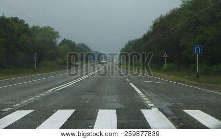 A Highway Landscape With Moving Cars At Daytime By Misty Road