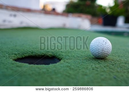Golf Ball And Hole In A Minigolf Field