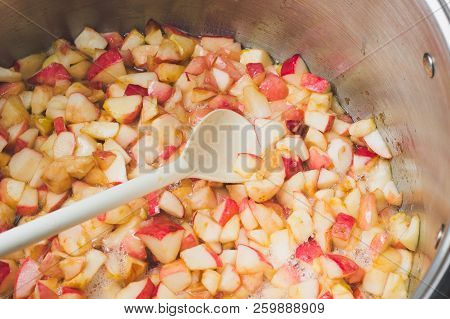 Cook Apple Jam And Stir With A White Plastic Spoon. Process Of Making Apple Jam Marmalade At Home