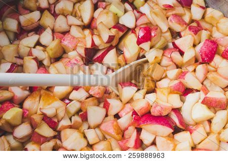 Cook Apple Jam And Stir With A White Plastic Spoon. Process Of Making Apple Jam Marmalade At Home
