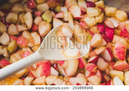 Cook Apple Jam And Stir With A White Plastic Spoon. Process Of Making Apple Jam Marmalade At Home