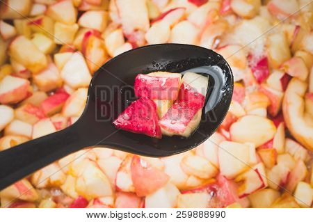 Cook Apple Jam And Stir With A White Plastic Spoon. Process Of Making Apple Jam Marmalade At Home