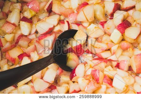 Cook Apple Jam And Stir With A White Plastic Spoon. Process Of Making Apple Jam Marmalade At Home