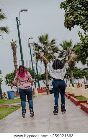 Two Chubby Girls With Inline Skates In The Park