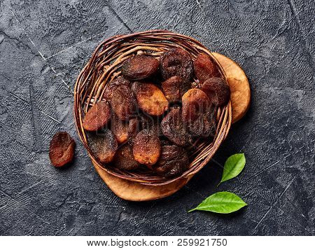 Brown Sun Dried Apricots On Black Table. Top View.