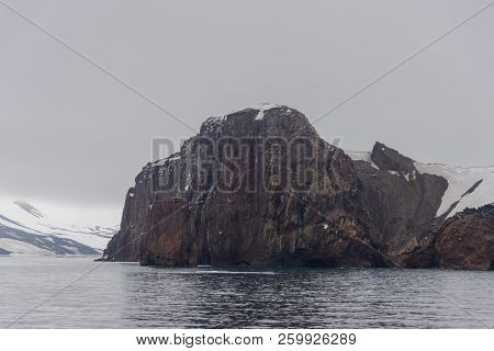 Rocks On Deception Island Beach And Sea With Ice In Antarctica