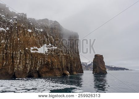 Rocks On Deception Island Beach And Sea With Ice In Antarctica