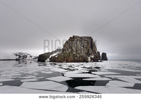 Rocks On Deception Island Beach And Sea With Ice In Antarctica