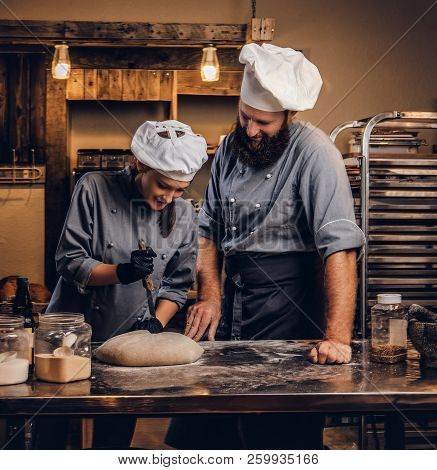 Chef Teaching His Assistant To Bake The Bread In A Bakery.