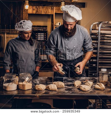 Chef Teaching His Assistant To Bake The Bread In A Bakery.