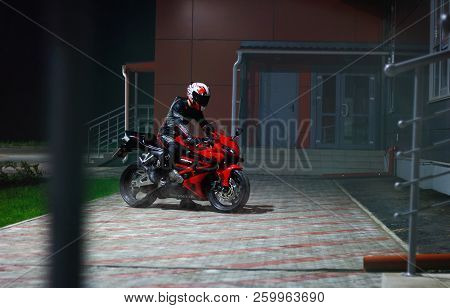 Krasnoyarsk, Russia - September 8, 2018: Beautiful Motorcyclist In Full Gear And Helmet In The Dark 