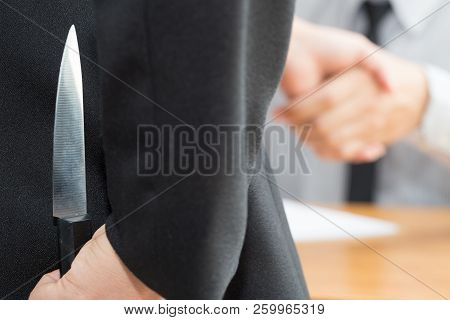 Treachery, Two Business Making Handshake A Deal But Hiding Knives