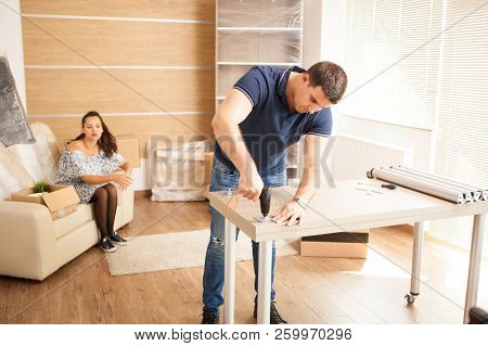 Man Uses Tools To Assembly Furniture In New House.